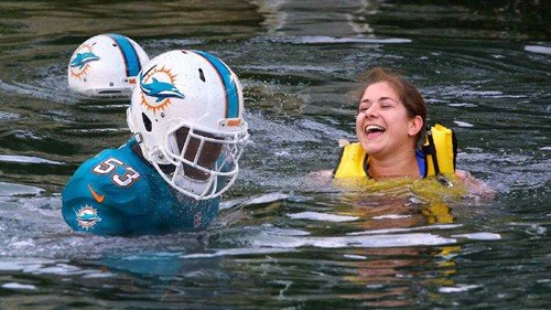 Picture from the Onion: Florida Resort Allows Guests To Swim With Miami Dolphins